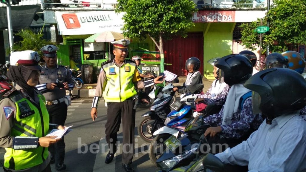 Polwan Bagikan Brosur Keselamatan Lalu Lintas di Lampu Merah