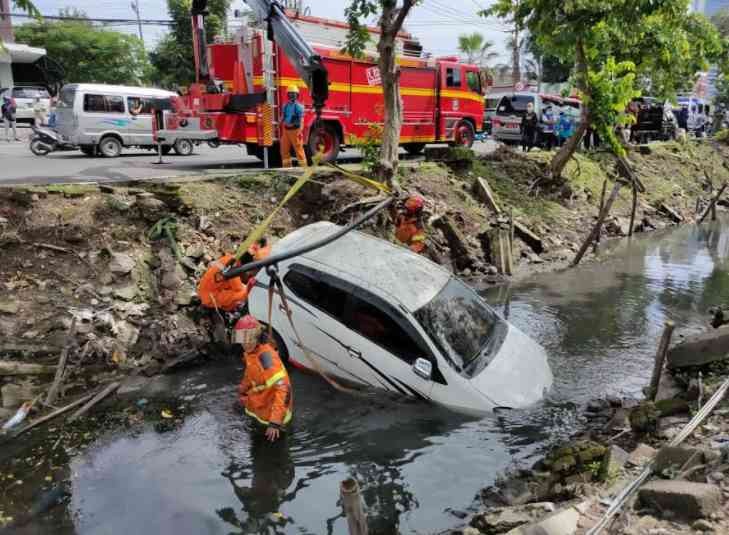 Main Ponsel, Pengendara Mobil Masuk Got Jemursari Surabaya