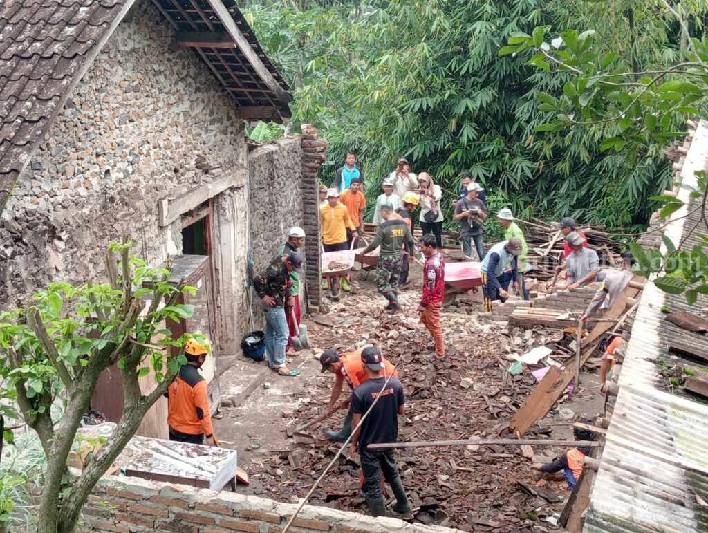 Rumah Warga Plangkrongan Magetan Ambruk Timpa Motor Warga dan petugas gabungan BPBD Magetan serta TNI Polri saat melakukan kerja bakti pembersihan rumah yang ambruk milik Darmawan Budi Prasetya (64) warga Desa Plangkrongan, Poncol, Magetan, Jawa Timur, Selasa (31/01/2023)