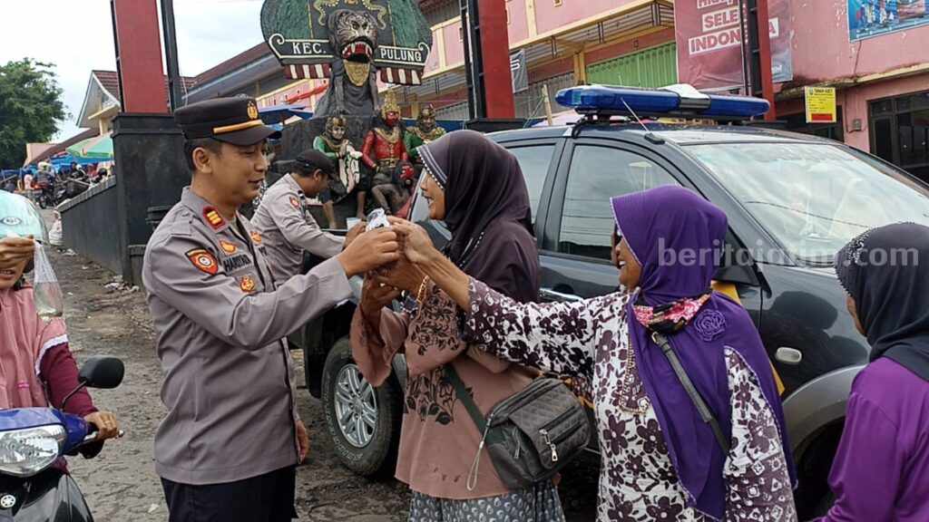 Anggota Polsek Pulung saat membagikan ikan cupang kepada masyarakat yang ada di Pasar Pulung. (Foto/Humas Polres Ponorogo)