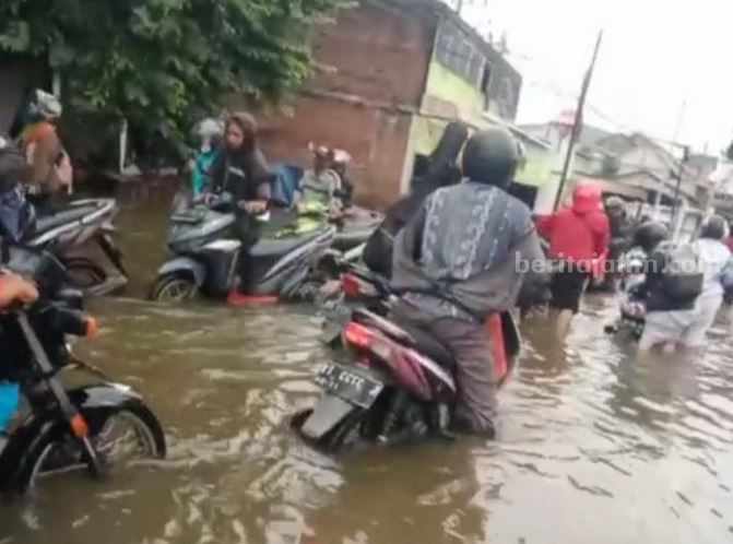 Pengendara roda dua terjebak banjir saat melintas di Jalan Raya Boboh Menganti Gresik.