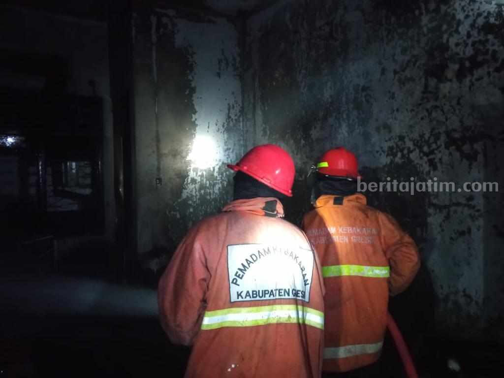 Petugas Damkarla Gresik berusaha memadamkan api