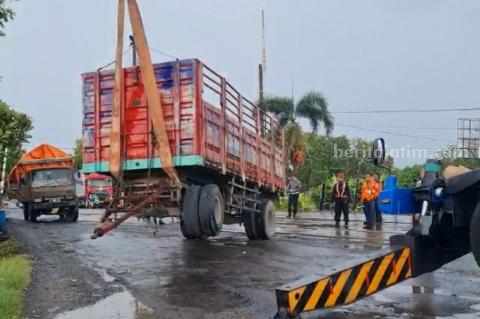 Truk gandeng yang mengalami patah as di atas perlintasan rel KA di Lamongan (Foto: Ist).