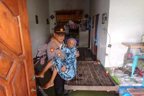 Polisi Lamongan saat menggelar patroli kesehatan secara door to door di rumah warga terdampak banjir.