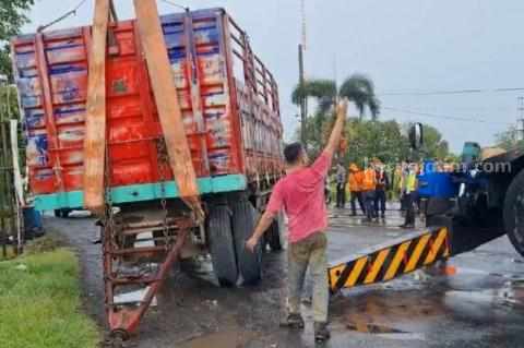 Truk gandeng yang mengalami patah as di atas perlintasan rel KA di Lamongan (Foto: Ist).