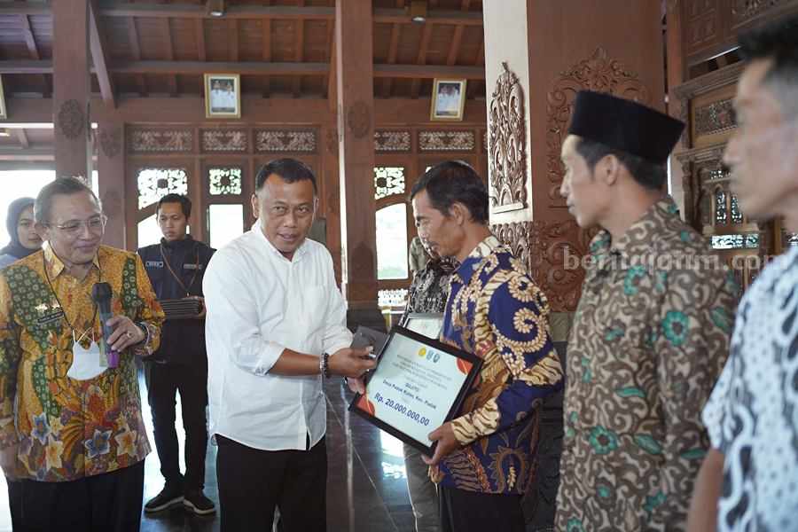 Didampingi Syamsul Ma'arif, Bupati Sugiri Sancoko memberikan bantuan ganti rugi secara simbolis kepada peternak yang terdampak PMK. (Foto/Pemkab Ponorogo)