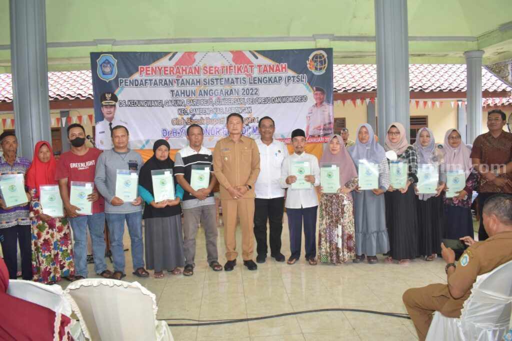 Bupati Lamongan Serahkan 7.578 SHAT Program PTSL Bupati Lamongan Yuhronur Efendi saat menyerahkan sertifikat kepada warga di Desa Kedungwangi Sambeng, Lamongan.