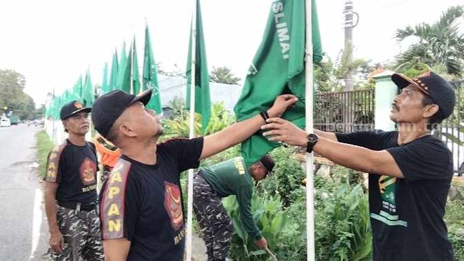 Pemasangan bendera NU di depan Kantor PCNU Kabupaten Mojokerto. [Foto : Misti/beritajatim.com]