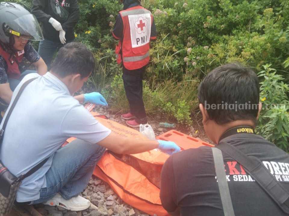Petugas saat mengevakuasi jenazah di Ketintang.