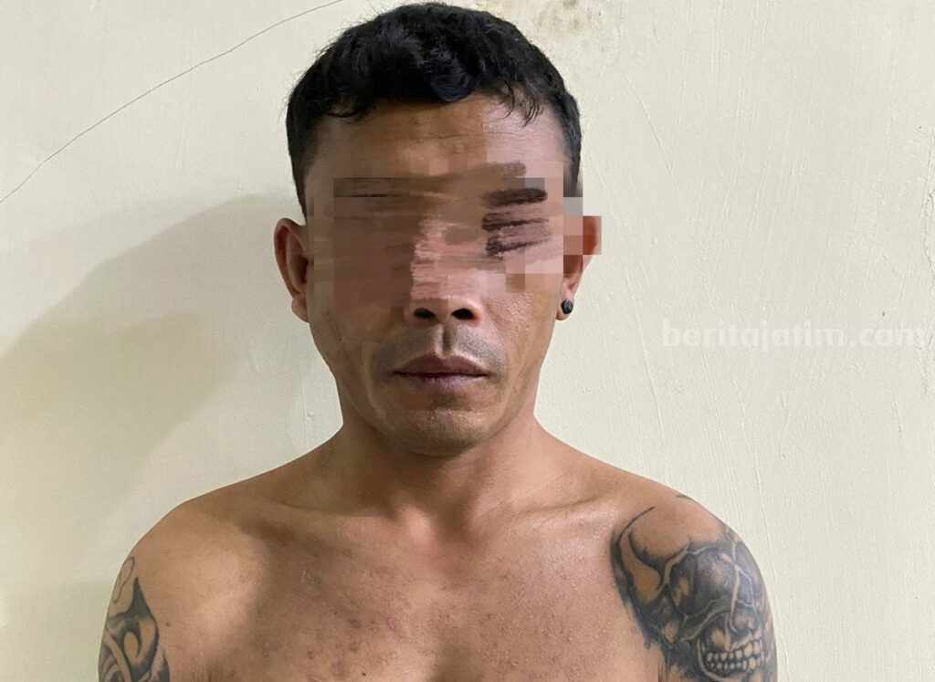 Pelaku HP (38) setelah diamankan oleh Kasat Reskrim Polres Pasuruan.