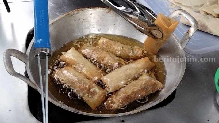 Bersama sang suami, Anggun menyiapkan lumpia pesanan pelanggan. [Foto : Misti/beritajatim.com]