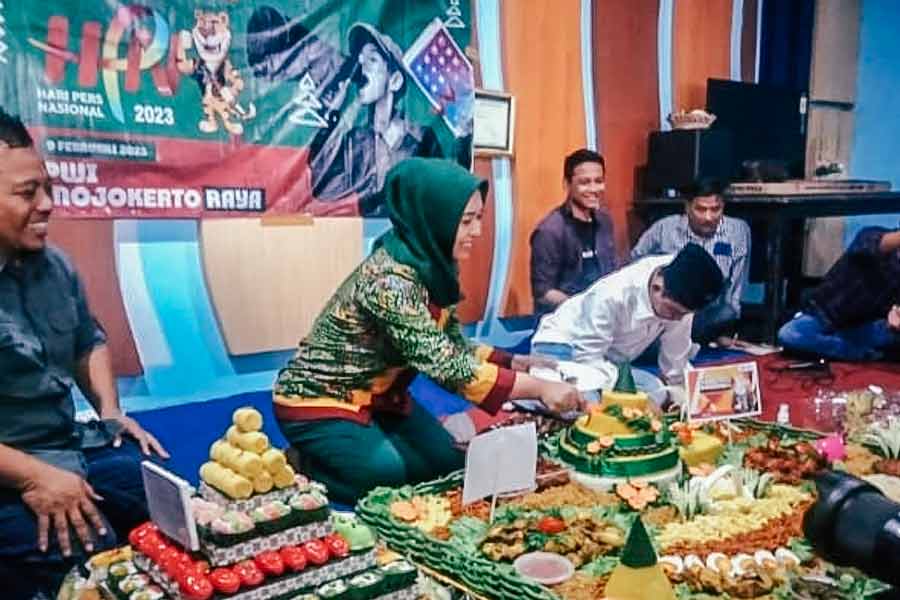 Wali Kota Mojokerto Ika Puspitasari memotong tumpeng dalam tasyakuran HPN tahun 2023. [Foto : Misti/beritajatim.com]