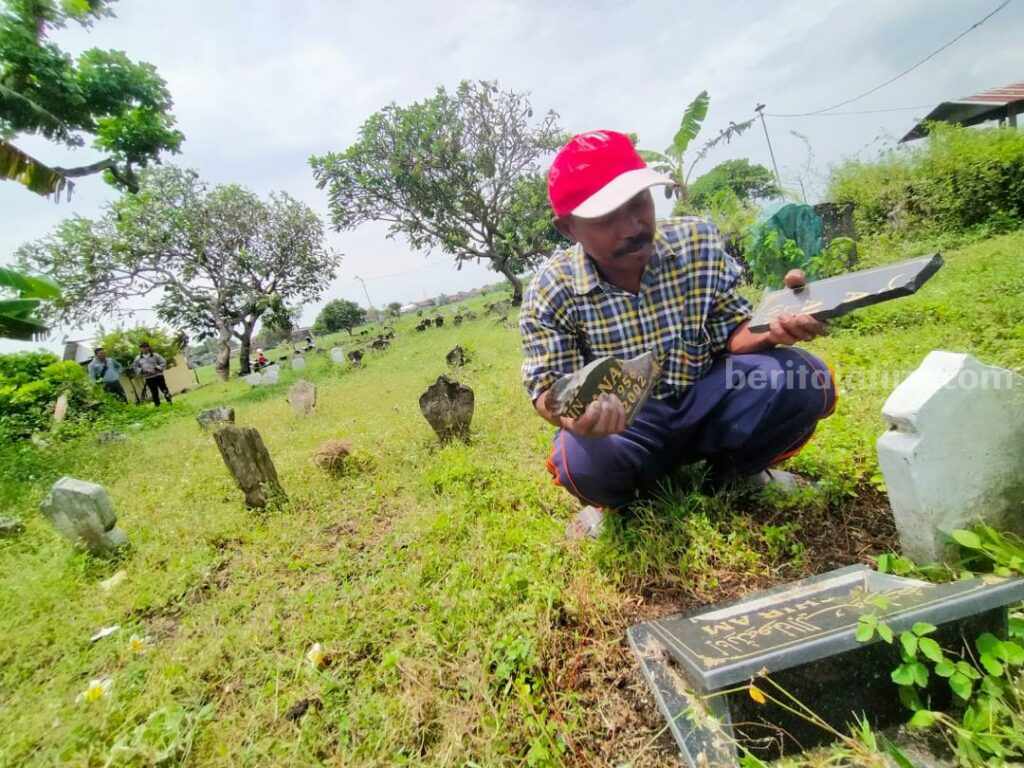 Khoiron warga Kelurahan Glanggang, Kecamatan Beji, Kabupaten Pasuruan saat menunjukan batu nisan yang sudah hancur.