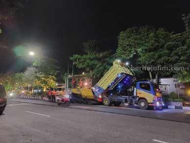 Petugas saat melembur pekerjaan pengaspalan di depan Jalan Yos Sudarso Ngawi, Jawa Timur, Rabu (8/3/2023)