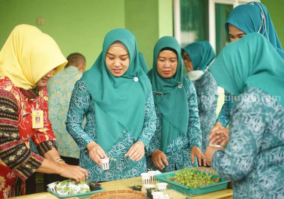 Ning Sasha Sosialisasi Pemanfaatan Lahan Pekarangan Keluarga Camat Gedangan dan Ning Sasha menanamkan bibit untuk pemanfaatan lahan pekarangan keluarga.