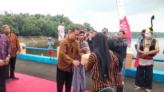Kepala Dinas Pekerjaan Umum dan Penataan Ruang Ngawi Muhammad Sadli saat memberikan Seserahan Agung secara simbolis di Waduk Pondok, Minggu (19/3/2023).