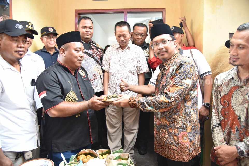 Syukuran. Gus Muhdlor menyerahkan makanan kenduren kepada Tohari