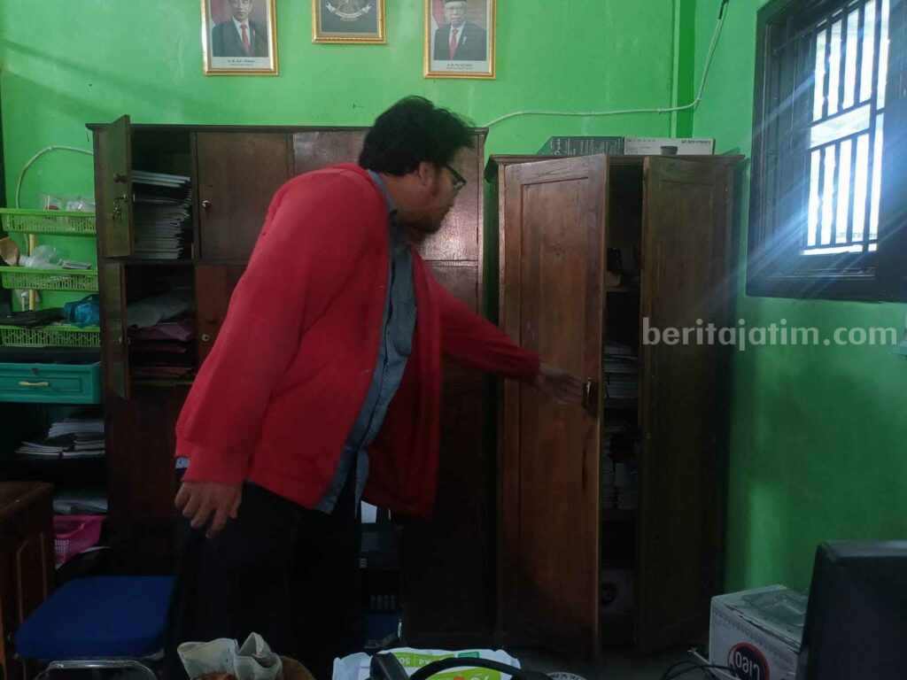 Salah satu guru menunjukkan lemari yang ada di ruang guru SMP swasta di Desa Jiyu, Kecamatan Kutorejo, Kabupaten Mojokerto yang dirusak pelaku. [Foto : ist]