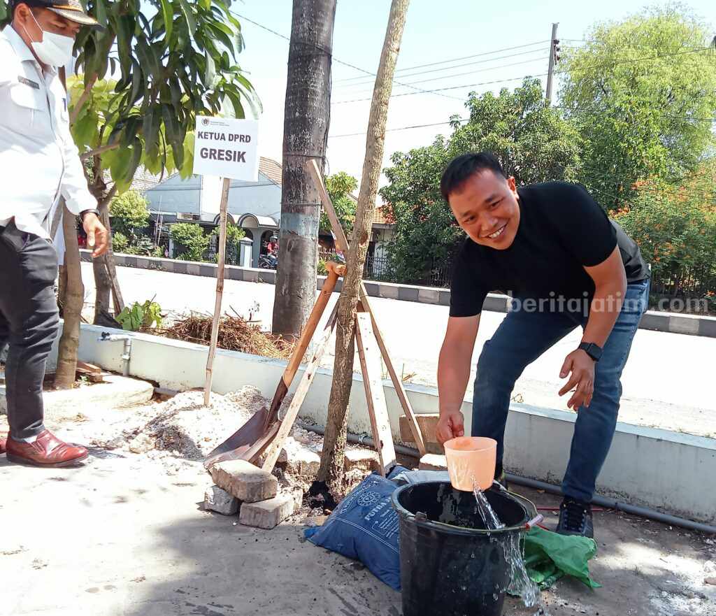 Ketua Dewan Gresik Abdul Qodir (kanan) saat menanam pohon tebebuya didampingi kepala desa pandanan