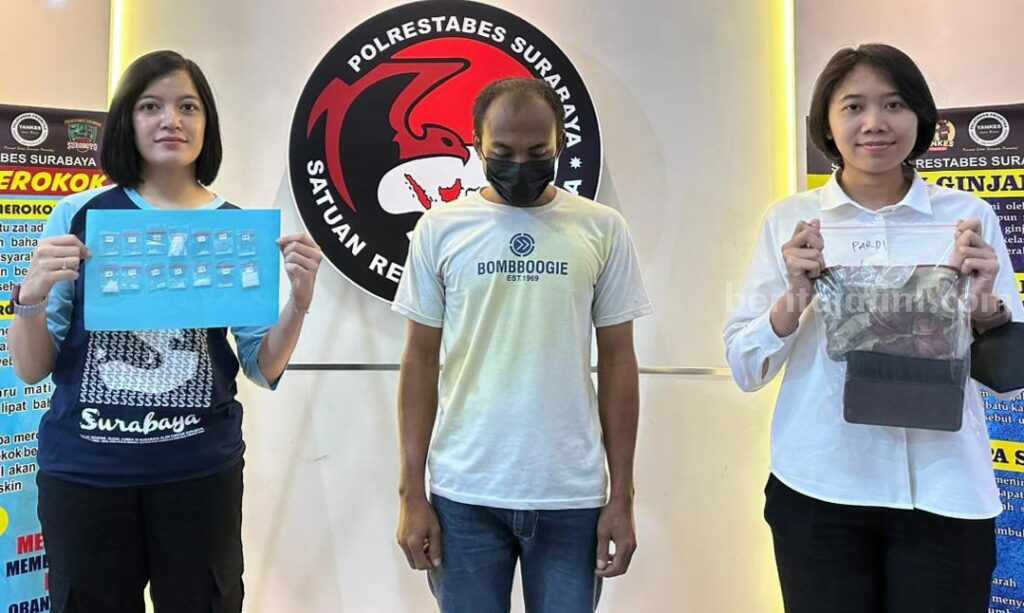 SP saat diapit dua petugas dari Satres Narkoba Polrestabes Surabaya. (Foto/ist)