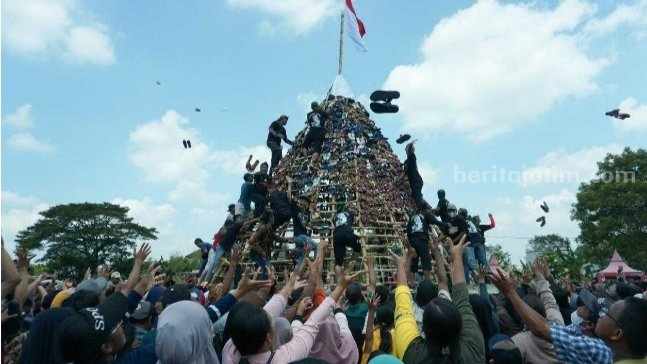 Warga berebut gunungan berisi sandal di Lapangan Prajuritkulon, jalan Cinde Baru, Kelurahan Prajuritkulon, Kecamatan Prajuritkulon, Kota Mojokerto. [Foto : ist]