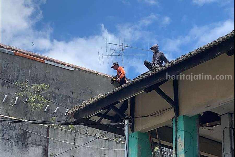 Pekerja mulai membongkar genting di Pasar Lanang. (Foto/Endra Dwiono)