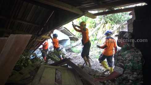 Hujan Deras 3 Jam, Rumah Warga Sine Ngawi Diterjang Longsor Petugas saat mengevakuasi material lonsgor di rumah Budiono Mingan di Desa Pocol, Sine, Ngawi, Jawa Timur, Jumat (24/3/2023).
