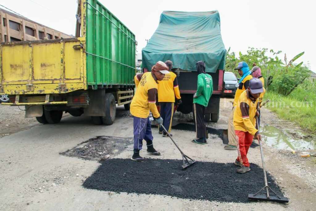 Beri Kenyamanan Pemudik, Lamongan Perbaiki Jalan Berlubang Jalan berlubang di Lamongan yang sedang diperbaiki menjelang Hari Raya Idulfitri 1444 H (Foto: A. Thoriq Hidayatullah/beritajatim.com).