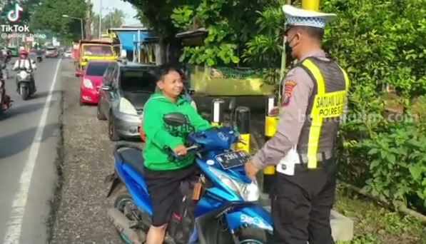 Anggota Satlantas Polres Blitar memberikan teguran kepada pengendara tunawicara yang tidak menggunakan helm.