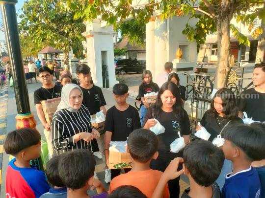 Inda Raya saat membagikan takjil pada anak-anak dan pengguna jalan di area Bakorwil Madiun bersama Pemuda Gereja GSJA Shekinah Glory Madiun, Selasa (11/04/2023)