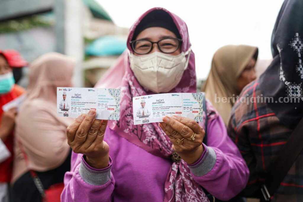 Warga menunjukkan kupon sembako murah dari PT SIG usai mengantre.