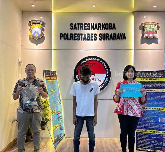 LD saat diapit dua petugas dari Satres Narkoba Polrestabes Surabaya. (Foto/ist)