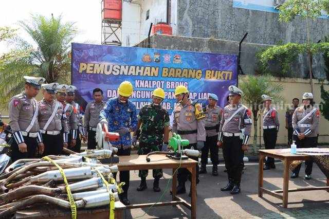 AKBP Muhammad Ridwan bersama Bupati Magetan Suprawoto saat pemusnahan ratusan liter miras dan knalpot brong di halaman Mapolres setempat, Senin (17/04/2023).