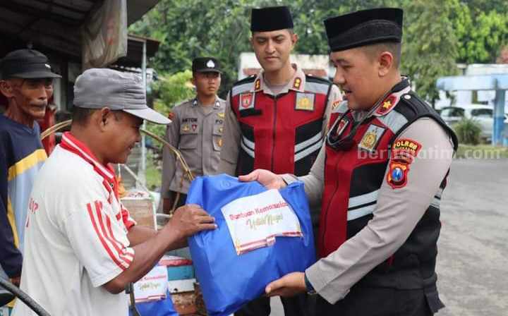 Kapolres Pamekasan, AKBP Satria Permana (tengah) menyaksikan proses pengeluaran paket sembako bagi keluarga kurang mampu di Pamekasan.