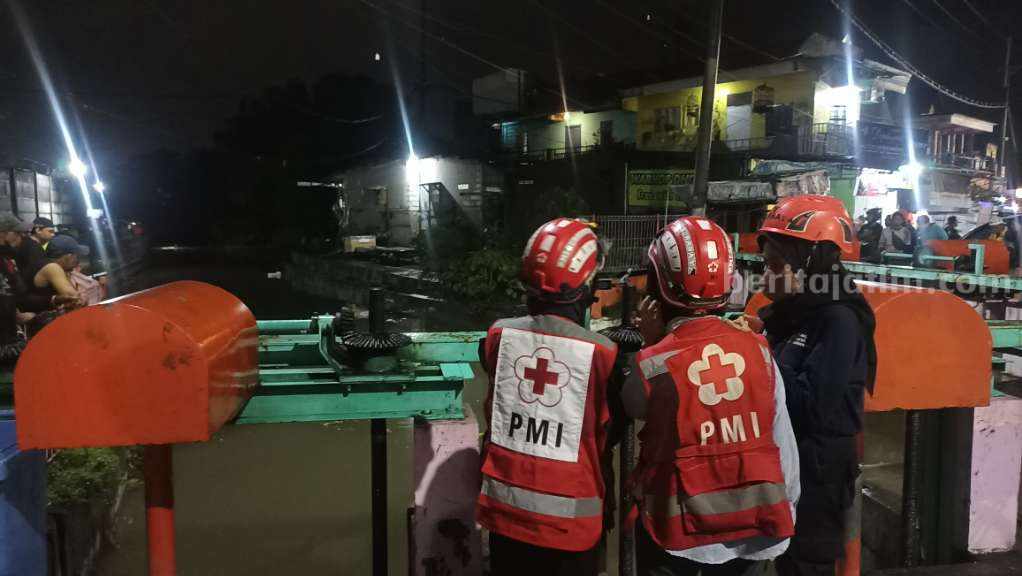 Bocah di Surabaya Hanyut di Sungai Simo Hilir Petugas PMI mengawasi di pintu air Simo Hilir untuk mencari korban tenggelam, Rabu (12/04/2023) malam. (Foto/anggadia)