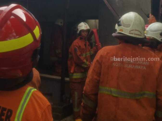 Petugas pemadam kebakaran saat melakukan evakuasi dan pembasahan di lokasi kebakaran di Manyar, Selasa (18/04/2023). (Foto/ist)