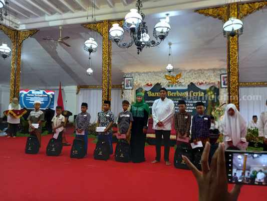 Gubernur Jawa Timur menyerwhkan santunan pada anak yatim (foto : Temmy/ beritajatim.com)