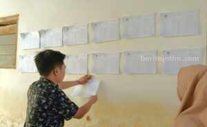 PPS Tempel DPS di Tempat Strategis, Warga Sumenep Cek Sudah Terdaftar atau Belum Anggota PPS saat menempelkan DPS di balai desa untuk mendapat tanggapan masyarakat