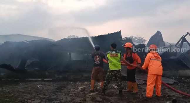 Petugas sedang memadamkan kobaran api yang melalap PT Charoen Pokphand di Jombang, Minggu (30/4/2023)