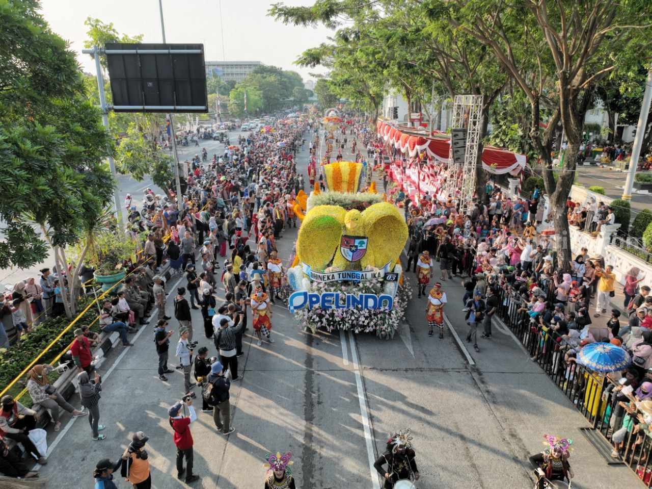 Warga Surabaya menyambut mobil hias Pelindo yang mengusung pesan keberagaman suku, ras, hingga disabilitas, dengan ikon Garuda besar pada Pawai Bunga dan Budaya Surabaya, Jawa Timur, Sabtu (27/5).