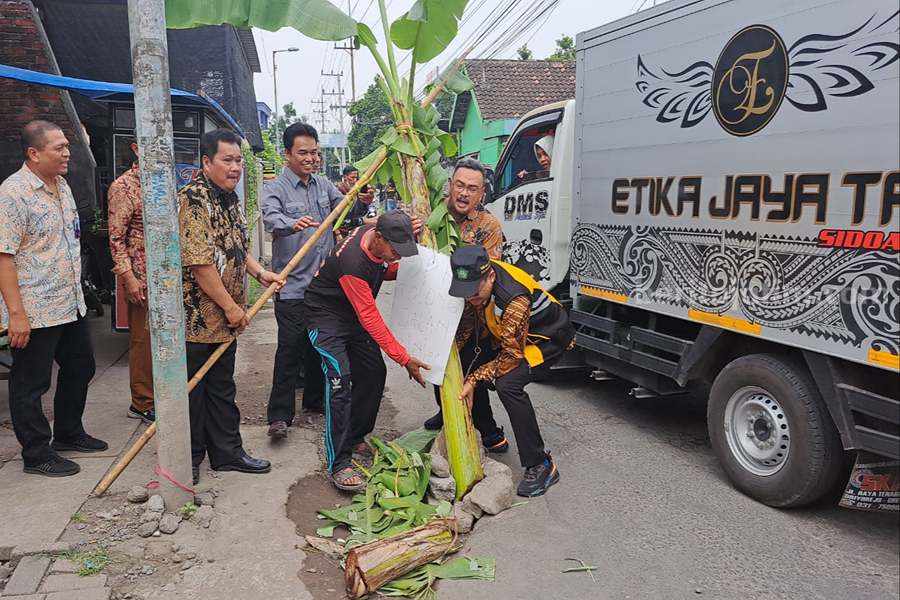 Kadin Perumahan, Permukiman Cipta Karya dan Tata Ruang dan Kadin PUBM SDA serta warga membersihkan tanaman pisang di tengah jalan