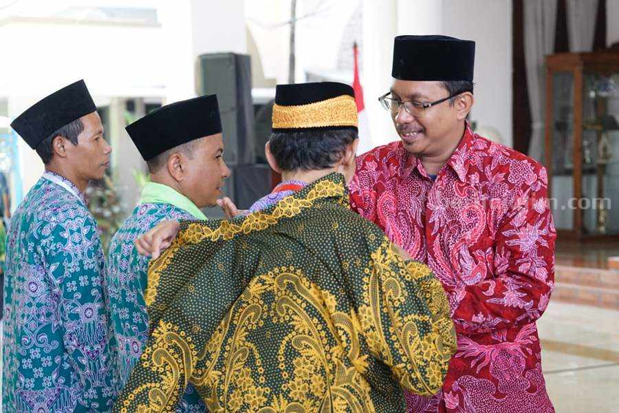 Bupati Sidoarjo Gus Muhdlor secara simbolis memakaikan jas 3 perwakilan jemaah haji