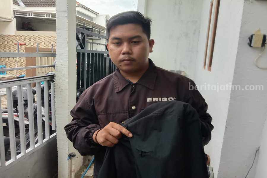 Satpam Pemkot Surabaya Dibegal di Jalan Pakal Huda sembari menunjukan kaletnya yang sobek akibat sabetan pisau dari pelaku begal di Jalan Pakal, Kamis (11/05/2023). (Foto/ist)