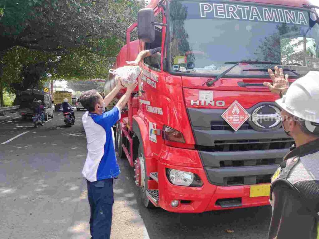 Aksi buruh PT Tjiwi Kimia saat membagikan nasi kotak kepada pengguna jalan di depan pabrik PT Tjiwi Kimia Jalan Raya Surabaya - Mojokerto km 44, Desa Kramat Temenggung, Kecamatan Tarik, Kabupaten Sidoarjo. [Foto : ist]