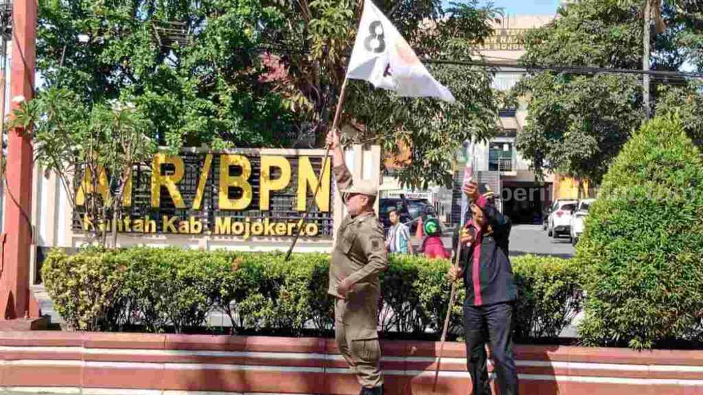 Anggota Satpol PP Kota Mojokerto mengamankan bendera parpol di jalan protokol Kota Mojokerto. [Foto : ist]