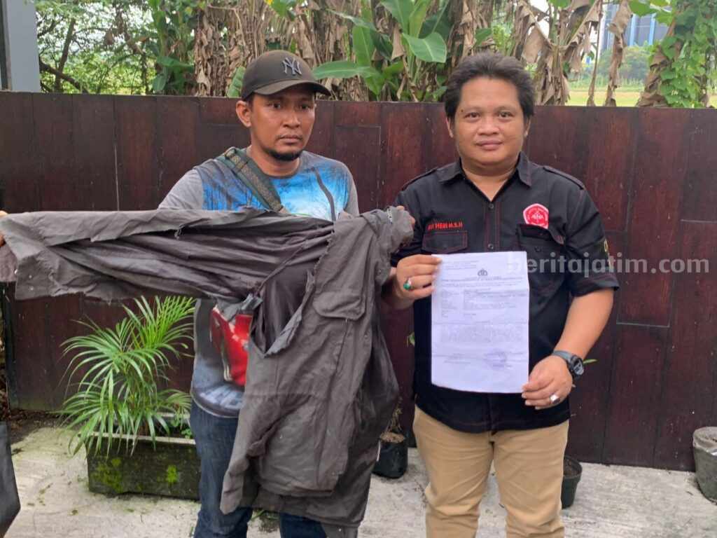 Sejumlah Oknum Sekuriti Pelabuhan Jamrud Dilaporkan ke Polres Pelabuhan Tanjung Perak Dwi Hery Mustika (kanan) bersama kliennya usai melaporkan kejadian pengeroyokan oleh oknum security pelabuhan Jamrud. (Foto/Dwi Heri for Beritajatim.com)