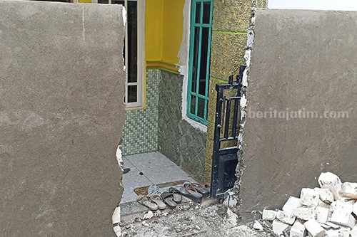 Tembok yang menghalangi keluar masuk rumah Tina yang sedang dibongkar. [Foto:Diah Ayu/beritajatim.com]