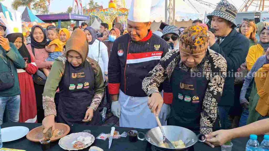 Wali Kota Mojokerto, Ika Puspitasari bersama suami Supriyadi Karima Saiful memasak Tahu Tek di halaman Sunrise Mall Kota Mojokerto. [Foto : Misti/beritajatim.com]