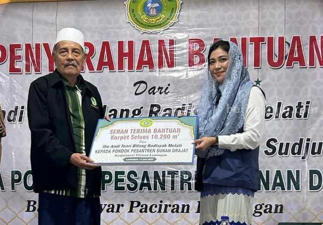 Mbak Bibie saat menyerahkan bantuan karpet kepada Pengasuh Ponpes Sunan Drajat Lamongan.
