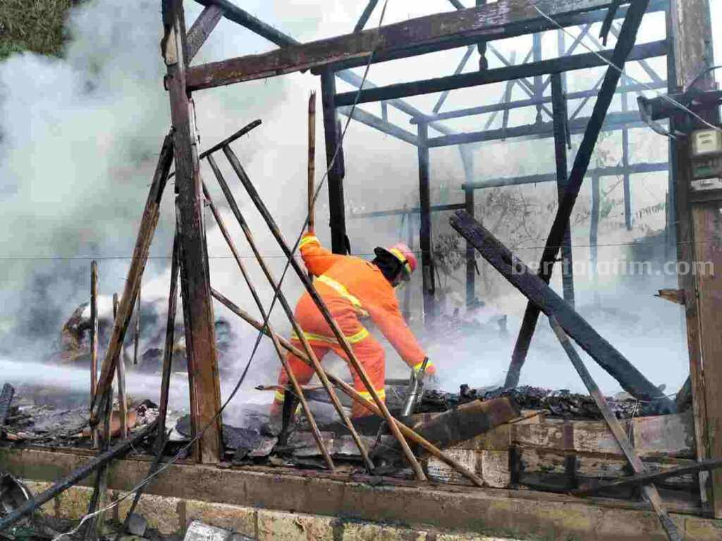 Petugas dari Pertamina sedang memadamkan rumah yang terbakar